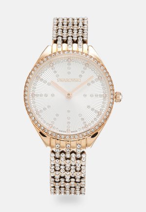 Swarovski-Uhr mit einem Gehäuse aus roségold, silbernem Zifferblatt und Kristallakzenten. Verfügt über ein mit Juwelen besetztes Armband und ein strukturiertes Zifferblatt mit Sonnenstrahlenmuster.