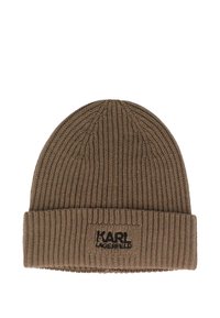 Bruine gebreide beanie met ribbeltextuur, voorzien van een zwart logopatch genaaid op de omgeslagen rand. Glad, warm materiaal zonder patronen.