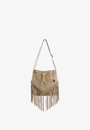 Beige suede bucket bag with long fringe detailing, drawstring closure, adjustable shoulder strap, and a small round metal charm.