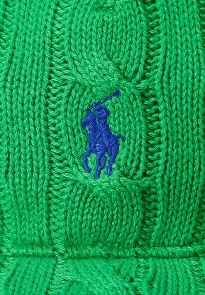Πράσινο πλεκτό πουλόβερ με σχέδιο καλωδίωσης, με μπλε κεντητό λογότυπο ενός αλόγου και αναβάτη στην αριστερή πλευρά.