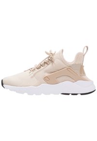 Beige sportskor med ovandel i mesh, rund tå och stötdämpande mellansula. Utrustad med dragflik och gummiyttersula för bra grepp.