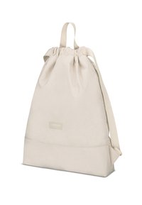 Sac à dos à cordon de tirage beige clair en matériau doux, avec une base plate, des bretelles ajustables et une petite étiquette de marque à l'avant.