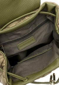 Sac en cuir vert de forme seau, avec un intérieur en toile beige, une poche zippée et une étiquette. Il dispose d'une fermeture à cordon et d'une texture lisse.