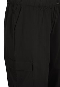 Black cargo pants with a drawstring waistband, side pockets, and a flap pocket on the thigh. Smooth fabric texture.