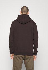 Bordowa bluza z kapturem ze sznurkiem i kieszenią kangurka, z prążkowanymi mankietami i dołem, wykonana z miękkiego, teksturowanego materiału.