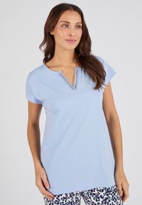 Camiseta de manga corta azul claro con escote en V y detalles de encaje. Tela de algodón suave, corte holgado, combinada con pantalones estampados.