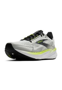 Valkoinen ja musta juoksukenkä, jossa on verkkovuori, heijastavat hopeiset yksityiskohdat ja kirkkaat vihreät yksityiskohdat. Paksu pohja vaimennusta ja tukea varten.