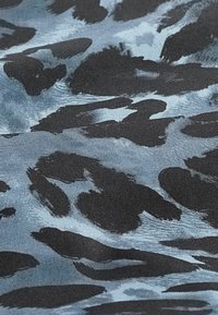 Katoenen stof met een blauw en zwart abstract luipaardmotief; gestructureerd oppervlak met duidelijke penseelstreken.