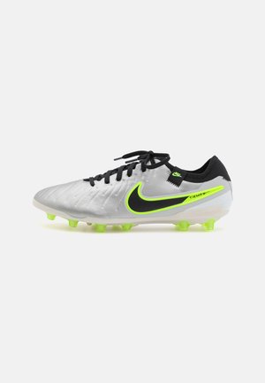Scarpette da calcio Nike Tiempo con una toma in sintetico argentato, accenti neri, logo verde neon e tacchetti verdi brillanti su una suola bianca.