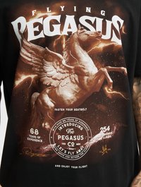 Sort bomulds T-shirt med en stor trykt grafik af en vinget hest, svulmede skyer og fed hvid tekst; inkluderer detaljerede accenter og vintage stil.