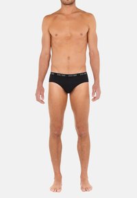 Svarta bomullsboxershorts med en figurnära design, med ett midjeband som har varumärkets namn i vitt text. Slät yta och utan mönster.