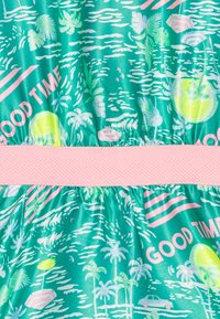 Tkanina s tropickým vzorem v odstínech zelené s růžovými akcenty. Obsahuje palmy, vlny a široký růžový pás.
