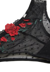 Sort mesh lingeri med rød blomsterbroderi og grønne accenter, med et prikket mønster og blonderkant langs kanterne.