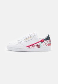 Vita Adidas-sneakers med rosa och gröna blommönster på sidan och hälen, guld Adidas-logotyp på snörpanelen och geometrisk design på hälfliken.