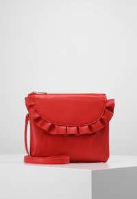 Rød læder crossover taske med en bølget flap, lynlåslukning og en aftagelig rem. Glat tekstur og vinkelret design.