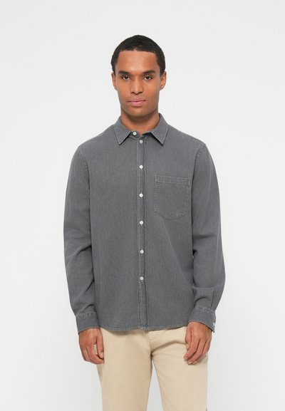 Chemise grise à boutons en tissu doux, avec une poche poitrine, des manches longues et un col classique à boutons.