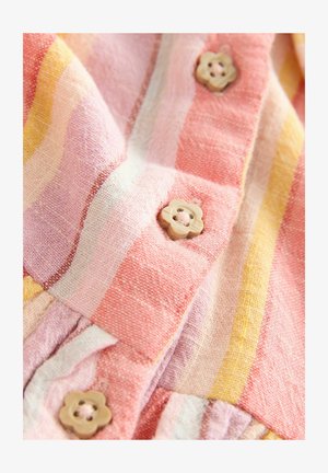 Len z pionowymi różowymi, żółtymi i białymi paskami; posiada drewniane guziki w kształcie kwiatów oraz detal w postaci marszczonego pasa.