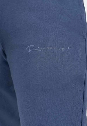 Marineblauwe sportbroek van zachte stof met een geborduurd logo nabij de taille, met een gladde textuur en een aansluitend ontwerp.