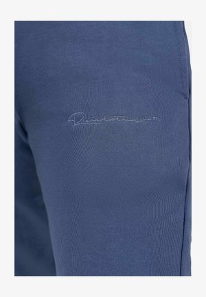 Pantaloni sportivi blu navy realizzati in tessuto morbido con un logo ricamato vicino alla vita, caratterizzati da una superficie liscia e un design aderente.