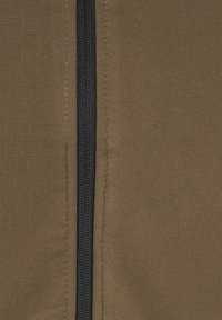 Tissu vert olive avec une fermeture éclair noire verticale, texture lisse avec des détails de couture subtils de chaque côté de la fermeture éclair.
