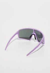 Lunettes de soleil violettes de forme rectangulaire, avec des verres foncés et des branches fines et texturées. Elles présentent un nez bien marqué et un minimum de matériel.