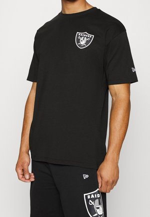 Camiseta de algodón negra con un logo blanco de los Raiders en el pecho. Diseño de mangas cortas y cuello redondo. Textura suave.
