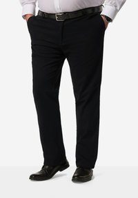 Pantaloni neri da uomo con design a gamba dritta e tasche anteriori. Abbinati a scarpe in pelle nera e a una cintura nera. Tessuto con una superficie liscia.