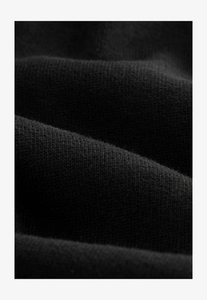 Material textil tricotat negru, cu o textură moale, prezentând variații subtile în țesătură, creând un aspect neted și fluid în plierile suprapuse.