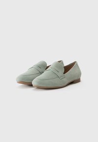Mocassins en daim vert menthe avec un petit talon, présentant un design supérieur cousu et un bout rond. Construction légère et profil simple.