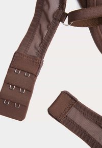 Extensor de sujetador marrón con ganchos y secciones de tela de malla sobre fondo blanco, mostrando los componentes de sujeción y ajuste.