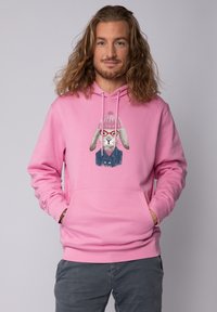 Roze katoenen hoodie met een kangoeroezak, voorzien van een grafisch motief van een konijn dat een bril en een gebreide muts draagt. Zachte textuur, standaard pasvorm.