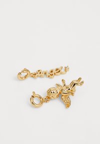 Gold-tone charm with the word "Angel" and a small cherubic figure. Smooth finish, intricate detailing on the figure, plus a clasp closure.