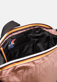 Interno di una borsa in nylon rosa con fodera nera, rifiniture a strisce multicolori, logo K-WAY e tasche organizzative. Apertura con zip visibile.