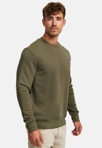 Olivgrüner Sweatshirt mit Rundhalsausschnitt, gerippten Bündchen und Saum. Verfügt über ein kleines schwarzes Logo auf der Brust. Weicher, strukturierter Stoff.