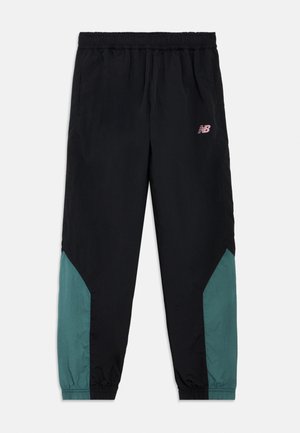 Pantalon de jogging noir avec des panneaux bleu sarcelle sur le bas des jambes, taille et poignets élastiques, et logo New Balance rose sur la cuisse droite.