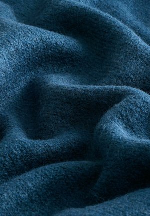Dunkelblaues Wollgewebe mit einer weichen, strukturierten Oberfläche, die in sanften Wellen und Falten fällt und seine Tiefe sowie die reiche Farbe betont.