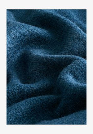 Dunkelblaues Wollgewebe mit einer weichen, strukturierten Oberfläche, die in sanften Wellen und Falten fällt und seine Tiefe sowie die reiche Farbe betont.