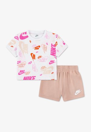 Hvid kortærmet skjorte med lyserøde, orange og beige Nike-logoer kombineret med lysebrune shorts med elastisk talje og et hvidt Nike-logo.