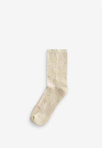 Bežna socka izrađena od teksturiranog pletenog materijala. Ima suptilan sjaj i rebrasti rub, s laganim speckama kroz cijelu dužinu.