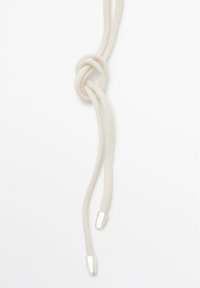 Bolo slips med en knude lavet af blødt, off-white materiale, med to glatte sølvtips i enderne.
