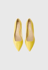 Scarpe gialle in pelle con punte affilate, dal taglio basso e una texture liscia. Marchio dorato all'interno. Design classico adatto per occasioni formali.