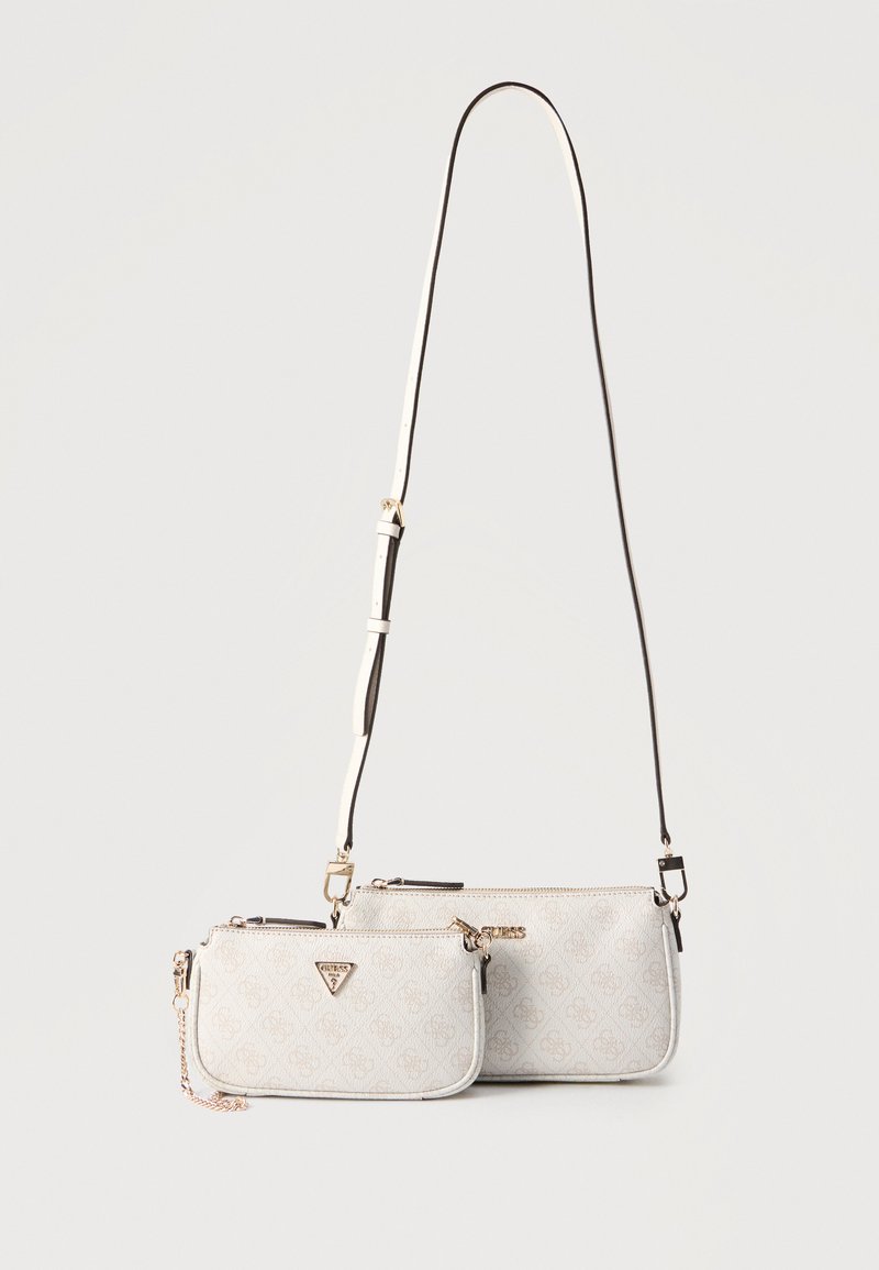 Δύο μικρές μπεζ σχεδιαστικές τσάντες χιαστί με χρυσαφί μεταλλικά στοιχεία και ρυθμιζόμενο λουρί, η μία με λεπτομέρεια αλυσίδας, δίπλα-δίπλα σε λευκό φόντο.