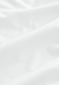 Witte katoenstof met een zachte structuur, met zachte plooien en een subtiele glans, die een delicate valdemonstratie creëert.