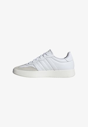 Scarpe sportive bianche con tomaia sintetica liscia, dettagli in suede grigio chiaro, sei occhielli e suola in gomma bianca texturizzata.