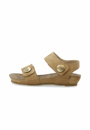 Brązowe zamszowe sandały odkryte z dwiema regulowanymi ramiączkami z dużymi okrągłymi metalowymi guzikami, płaska podeszwa i wsparcie kostki.