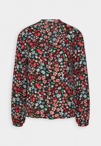 Blouse fleurie en tissu noir, présentant un mélange de fleurs rouges, bleues et roses. Manches longues avec poignets à boutons et encolure en V.