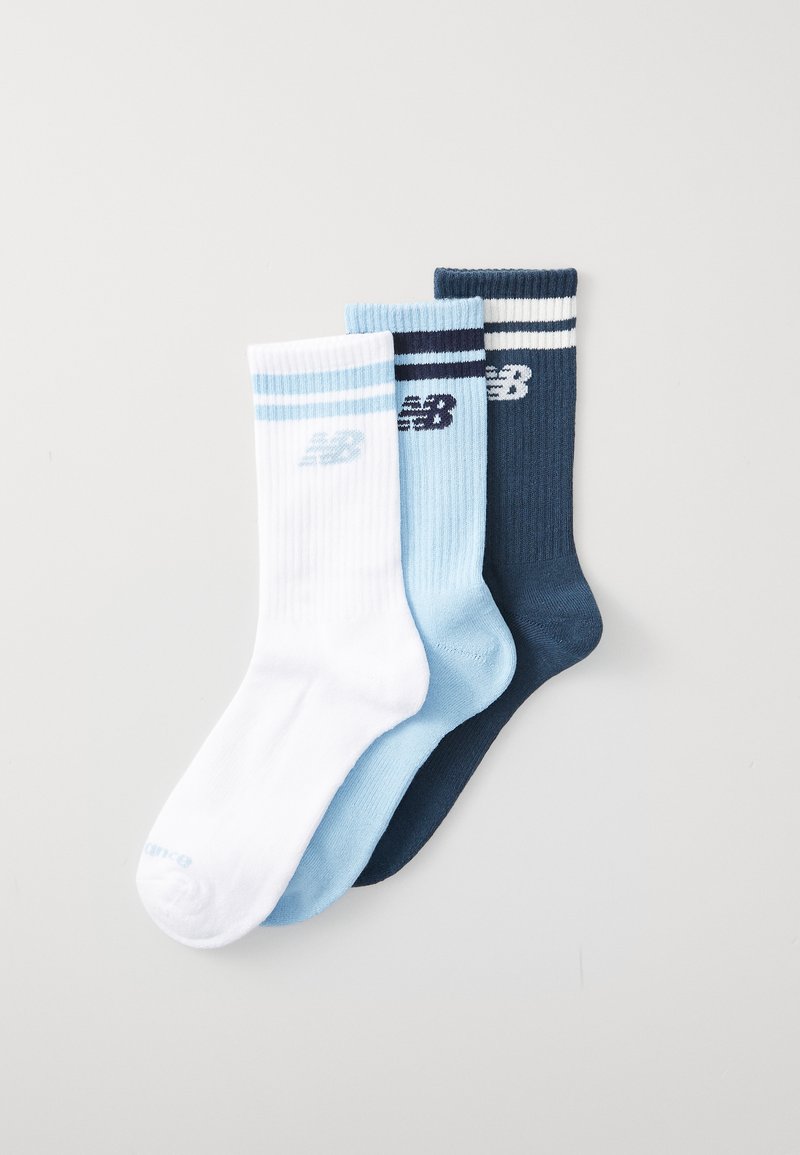 Set med tre strumpor: vita med ljusblå accenter, ljusblå och mörkblå med vita ränder. Ribbat mönster med New Balance-logotyp.