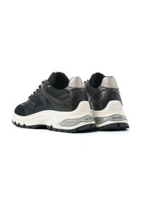 Pair of black and white Via Vai sneakers with textured metallic detail on heels and thick rubber soles, rear angled view on white background.