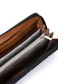 Portafoglio nero con chiusura a zip e dettagli in pelle marrone, diverse fessure per carte e un rivestimento grigio con un motivo a rombi. Include una tasca per monete con zip.
