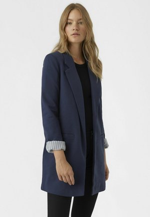 Blazer bleu marine avec une coupe ajustée, fermeture à un bouton et poignets rayés retroussés. Tissu texturé avec poches latérales.